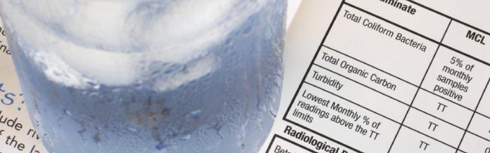 Glass of Water Sitting On Top Of A Water Quality Report