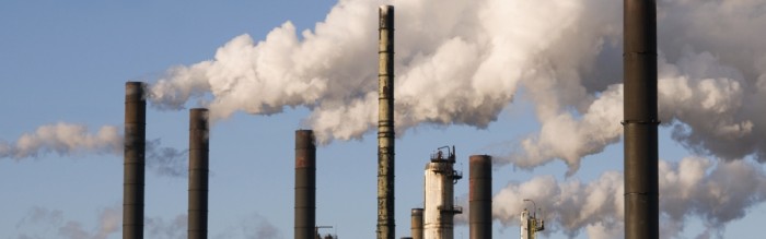 smoke being released into the sky from a refinery