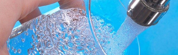 Person filling glass with tap water