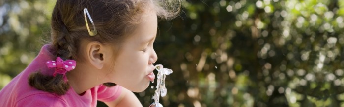 girl drinking water at fountain